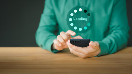 Young man using a mobile phone for download and update application and waiting to loading digital file data form the apps, very slow internet form wifi. Concept of waiting for load of loading symbol.