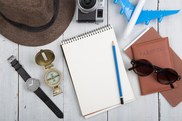Travel concept - sketchbook , Airline tickets, passport, sunglasses and camera on wooden desk. Copy space for text or logo