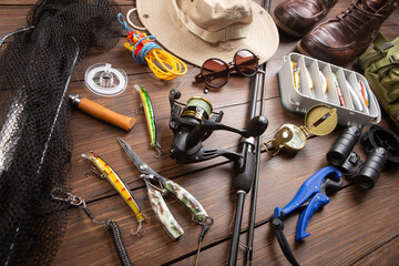 Fishing rod, tackles and other stuff for recreation activity on the wooden desk. Fishing season concept - 660375868