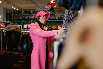 Woman shopping clothes. Shopper looking at clothing indoors in store