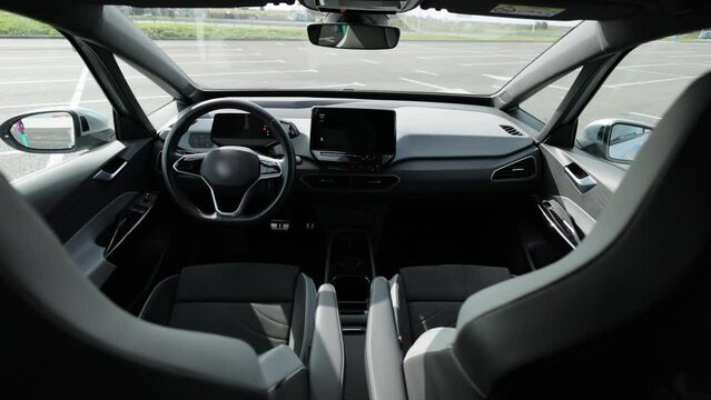 Electric car interior details adjustments. Inside car interior with front seats, driver and passenger, textile, multimedia, windows, console, gear shift, electric buttons, digital speedometer