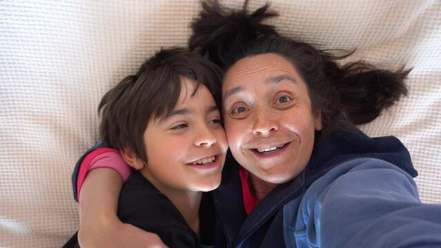 Fethiye, Turkey - 17th of May 2023: 4K Shaking Selfie of funny mother and son kissing on camera
