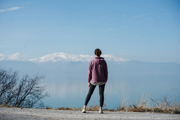 View point overlooking the lake and snowy mountains, the girl stopped to enjoy the beautiful nature