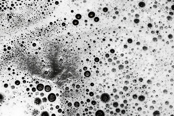 Soap bubbles texture. Black teflon frying pan cleaning. White suds pattern. Liquid detergent foam. Closeup shampoo bubbles. Washing dishes background. - obrazy, fototapety, plakaty