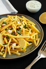 Homemade Greek Fries with Feta and Tzatziki on a Plate, side view.