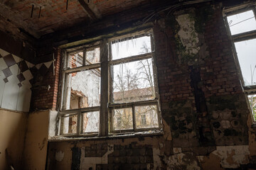 Fototapeta na wymiar Interior of shabby room of desolate building with crumbling brick walls and arches