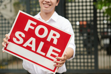 Big for sale sign in hands of real estate agent