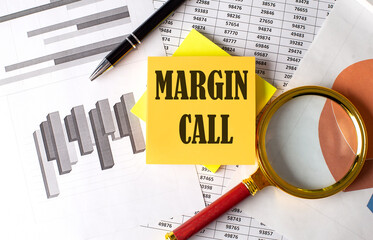 MARGIN CALL text on a sticky on red notebook on chart background