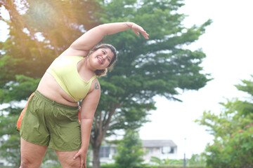 Young Asian beautiful plus size woman do exercise at park, bend her right arm to other side with...
