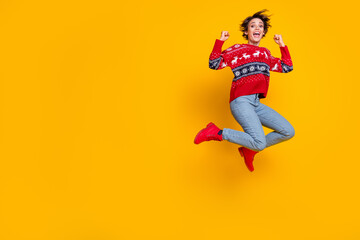 Full length photo of crazy overjoyed girl dressed ornament jumper flying in empty space win lottery isolated on yellow color background