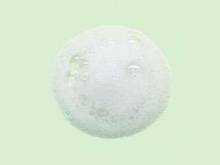 Skincare cleanser foam texture with bubbles isolated on green background. Soap shampoo face wash cleansing musse product sample