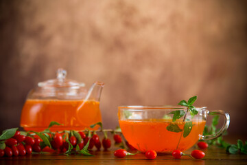 Prepared drink from ripe goji berries in a glass cup and teapot