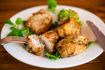 Fried pieces of chicken fillet breaded with spices and herbs in a plate .