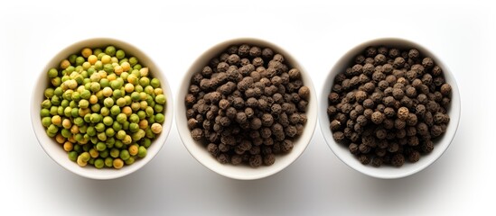 Trifecta of pepper spices Trio green white and black peppercorns in bowls Overhead shot With...