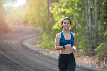 young fitness woman runner athlete running at road. athlete woman in running start pose on countryside street. sport tight clothes. bright sunset,  Healthy woman on morning road workout jogging.