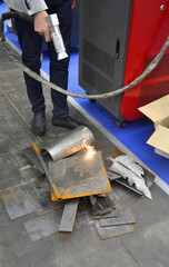 Laser metal cleaning. A man using laser metal cleaning machine to clean a metal surface from rust....