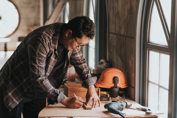 a Young man Carpenter works on woodworking machinery in a carpentry shop. The workshop looks professional, highly skilled, and the craftsmen are true craftsmen.