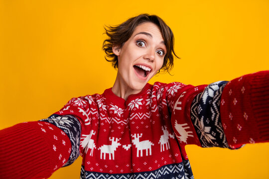 Photo of crazy ecstatic girl with bob hairstyle dressed red sweatshirt making selfie on new year isolated on yellow color background