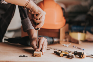 close-up hand a Young man Carpenter works on woodworking machinery in a carpentry shop. The workshop looks professional, highly skilled, and the craftsmen are true craftsmen.