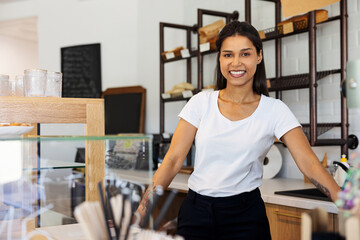 Portrait of smiling small business owner standing in bakery pastry shop
