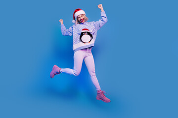 Photo of overjoyed cheerful girl wear trendy print penguin clothes celebrate seasonal offer run store isolated on blue color background