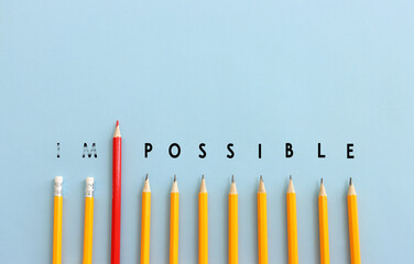 Pencils with the text impossible, stopping the domino effect. success and challenge concept