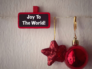 Holiday, celebration and Christmas concept. Joy To The World written on a wooden tag. With blurred...