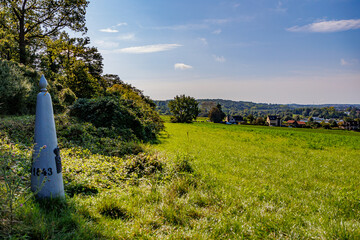 Border marker between Belgium and Holland on Caestert plateau, esplanade with green grass, hills...