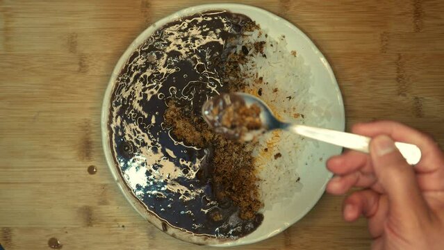 Table top view, POV: person eating feijoada and rice. Person eating farofa (cooked cassava flour). Feijoada on the table (bean stew). Plate of beans with rice, cooked manioc flour and olive oil