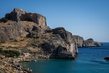 Enchanting Bay in Lindos, Rhodes: A serene Mediterranean retreat where moored boats meet the...