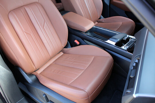 Premium electric car interior with light brown high-tech comfortable seats. Interior of prestige car. Comfortable perforated leather seats. Modern luxury car brown leather interior.
