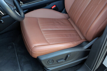 Brown leather driver seats. Interior of prestige car. Comfortable perforated leather seats. Modern...