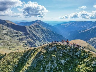 Aerial view of a group of people hiking on Moldoveanu Peak, Romania - obrazy, fototapety, plakaty