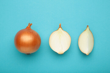 Fresh healthy onions and sliced onion on blue background
