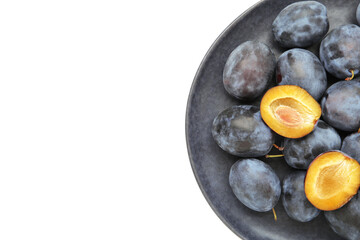 Fresh plums on dark plate isolated on white background
