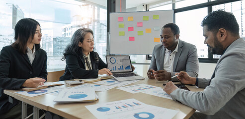 Business People Meeting using laptop computer,calculator,notebook,stock market chart paper for analysis Plans to improve quality next month. Conference Discussion Corporate Concept..