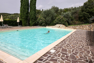Woman swimming in pool during vacation in Montemassi. Italy