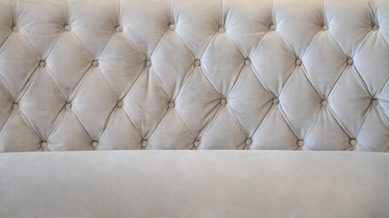 Closeup of a modern beige velvet sofa in the living room. Front view couch surface background for...