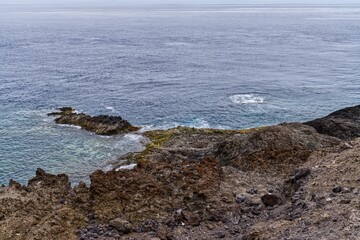 Scenic view of a rocky shoreline in a tranquil blue seascape