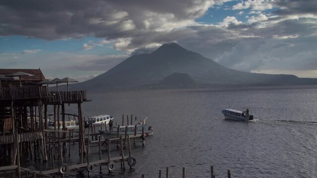 Boat sailing near to the marina in Lake Atitlan on a cloudy sunset in Santiago Atitlan, Guatemala