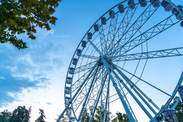 Fototapeta premium Big, tall white Ferris wheel in front of a perfect blue sky