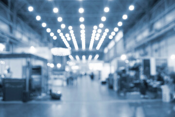 Large high building premises with people walking inside. Blurred background.