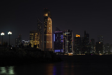 Colorful Abu dhabi city skyline at night and rise of full moon