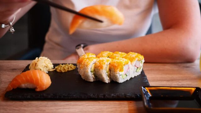 Woman eating sushi in an Asian sushi restaurant