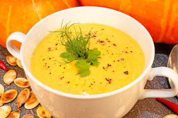 Pumpkin hot puree soup on a wooden table