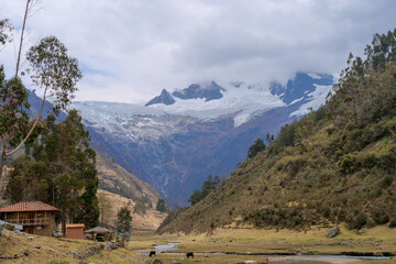 Houses in the valley of Jancapampa, Peru with the spectacular view of the peaks and glacier Pucajirca.