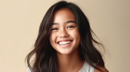 Fototapeta premium A cheerful teenage girl with a radiant smile against a soft, neutral studio backdrop.