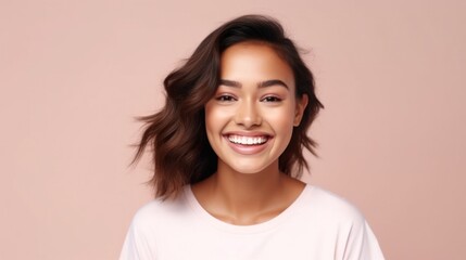 Fototapeta premium A cheerful teenage girl, radiating positivity, stands confidently in front of a soft, studio backdrop.