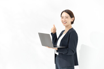 ノートパソコンを持ってグッドサインをする笑顔のビジネスウーマン