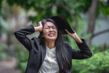 Angry Cry emotional woman in black suit screaming in green garden background. young asian woman angry pensive mad crazy screaming only one person in garden park outdoor.